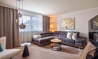 A modern living room with a cozy sofa and stylish furniture. Large windows let in plenty of light and create an inviting atmosphere.
