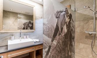A modern bathroom featuring an elegant sink and a shower wall depicting an image of an elephant. The walls are adorned in neutral tones, giving the space a stylish ambiance.