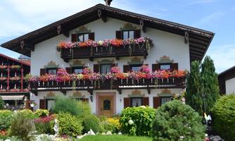 A traditional old house with beautiful flower balconies in a quiet environment. The garden is green and well-maintained.