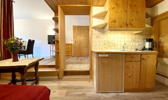 A cozy kitchen with wooden furniture and modern design. The room has a warm, inviting character.