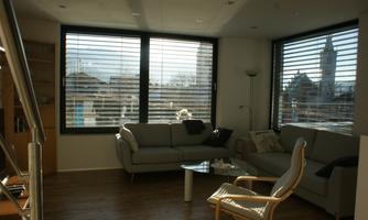 A modern living room with large windows and plenty of natural light and an inviting atmosphere.
