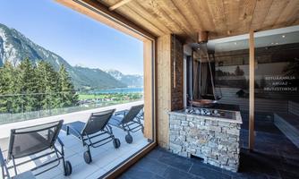 A modern wellness area with a view of the mountains. Comfortable loungers are available on the terrace.