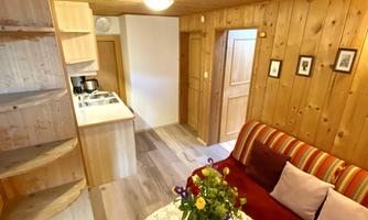 A cozy room with wooden paneling and a red sofa. A bouquet of fresh flowers is on the table.