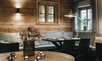 A cozy restaurant with wooden decor and a round table. Soft lighting creates an inviting atmosphere.