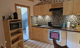 A cozy kitchen with wooden furniture and modern appliances. The room has an inviting atmosphere and a stylish tiled backsplash.
