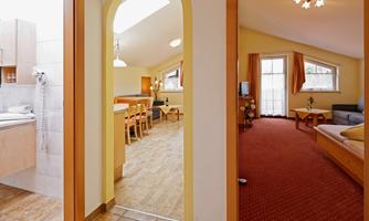 A bright and inviting room with an open layout. On the left side is a bathroom and on the right side a cozy living area.