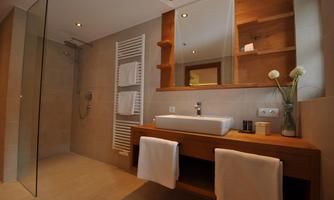 A modern bathroom with a glass shower and an elegant wooden sink. Bright tiles and decorative accessories create an inviting atmosphere.