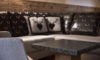 A cozy sofa with floral cushions and a modern table. The decor radiates a warm, inviting atmosphere.