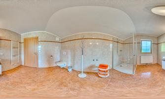 A modern bathroom with a bright tiled floor and elegant sanitary facilities. There is a shower, a sink, and generous countertop space.