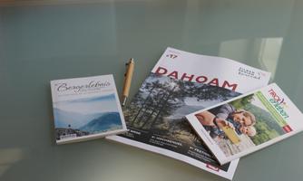 A table with various brochures and a pen. The brochures focus on recreational activities and excursions in nature.