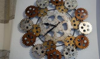 A creative wall clock made of various gears in different colors. It has a modern design and gives the room an industrial look.