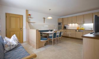 A bright kitchen with a cozy dining area and wooden furniture. The room is designed in a modern and inviting way.