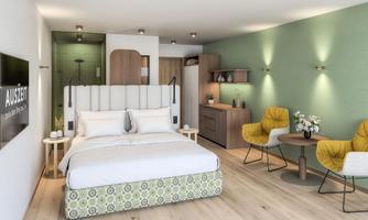 A modern hotel room with a large bed and stylish furniture. The walls are painted in soft colors, and there are cozy seating areas.