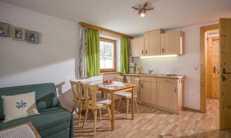 A cozy kitchen area with a table and chairs. Bright colors and natural wood elements create an inviting atmosphere.
