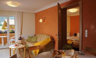 A cozy room with a sofa and dining table. Through the door, another room can be seen that offers a tranquil atmosphere.