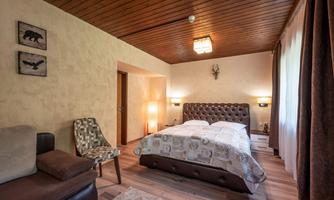A cozy bedroom with a large bed and modern furnishings. The walls are painted in soft colors, and there is a comfortable sofa.