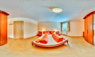 A cozy bedroom with wooden details and a large bed. The rooms feel bright and inviting.