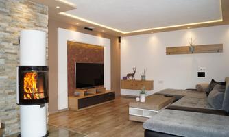 A modern living room with a cozy fireplace and a large television. The decor is simple and elegant, with soft lighting and a comfortable sofa.