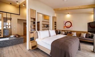 A modern room with a large bed and a cozy living area. The thoughtful decor creates a pleasant atmosphere.