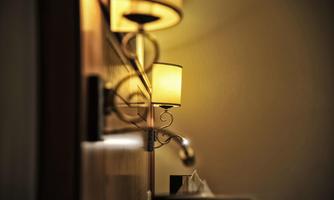 A soft lighting from a wall lamp in a cozy room. The background is blurred, creating an intimate atmosphere.