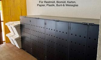 Waste separation bins for separate waste disposal. There is space for residual waste, organic waste, cardboard, paper, plastic, colored and white glass.