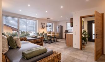 A modern apartment with a cozy living area. The space is bright and stylishly furnished, with an open kitchen and dining area.