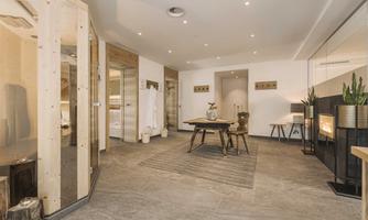 A modern and stylish wellness room with wooden details. The room is brightly lit and furnished with a cozy seating area.