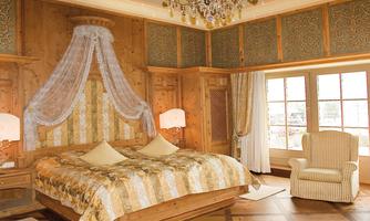 A stylish bedroom with wooden paneling and elegant furnishings. The large window provides a view of the surroundings and ensures plenty of daylight.