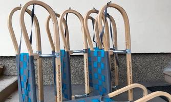 A set of wooden sleds in front of a building. It says "HAUS KAROLINE, Holiday Apartments" on it.