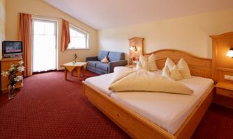 A cozy room with a double bed and a sofa. Large windows with plenty of daylight and a friendly atmosphere.