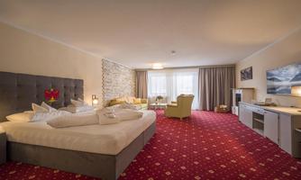 A modern hotel room with alarge bed and comfortable furniture. The room has large windows for plenty of daylight and a cozy atmosphere.