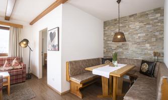 A cozy living area with a dining table and a comfortable seating corner. The walls are designed in a modern way and create an inviting atmosphere.