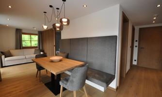 Modern interiors with a dining area and a cozy living area. Bright furniture and stylish lighting create a pleasant atmosphere.