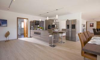 A modern, bright kitchen with elegant furniture and high-quality appliances. The open space conveys an inviting atmosphere.