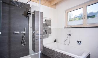 Modern bathroom with covered shower and freestanding bathtub. Bright walls and wooden details create a pleasant atmosphere.