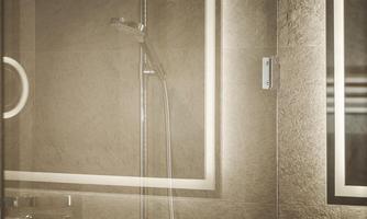 A modern shower with glass partition and stylish accessories. The walls are in neutral tones, giving the room an elegant look.
