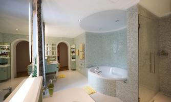 A modern bathroom with a bathtub and elegant tiles. The soft lighting creates a relaxed atmosphere.