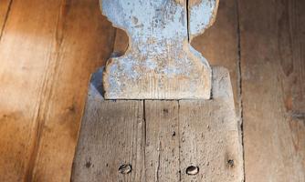 A unique, old wooden chair with a heart-shaped cutout in the back. The surface is worn and shows patina.