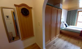 A cozy room with a spacious wardrobe and a large mirror. The atmosphere is inviting and bright.
