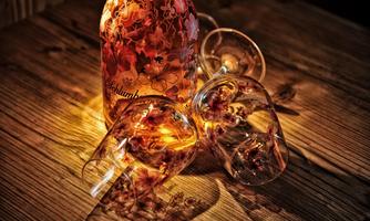 A bottle with a floral design stands next to two tipped-over glasses. The scene radiates a warm, inviting atmosphere.