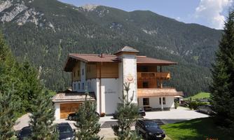 A charming hotel in the mountains, surrounded by green forests and majestic peaks. The clear air and tranquil surroundings invite relaxation.