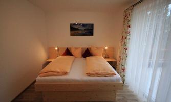 A cozy bedroom with a large double bed and soft colors.  
Large windows let in plenty of light and create a pleasant atmosphere.