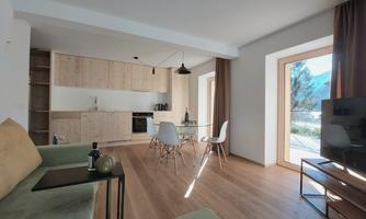 A modern apartment with bright wooden furniture and large windows. The space is friendly and bright, ideal for relaxed moments.