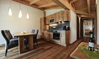 A modern kitchen with wood design and a dining area. The warm colors create an inviting atmosphere.