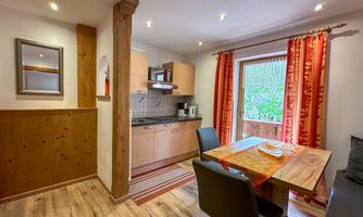 A cozy kitchen with a dining area and large windows. The warm colors and wooden paneling create an inviting atmosphere.