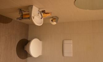 A modern bathroom with a small sink and a toilet. The walls are light and simply designed.