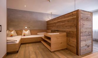 A modern room with wooden furniture and cozy seating. The neutral colors and thoughtful design create an inviting atmosphere.