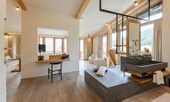 A modern room with a bathroom and large windows. The decor is minimalist and offers plenty of natural light.