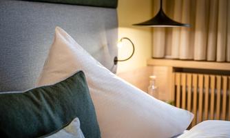 A cozy bedroom with soft pillows and gentle lighting. The decor exudes tranquility and comfort.