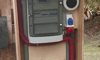 A technical installation in a wooden shelter. The device has various connections and is placed in a natural environment.